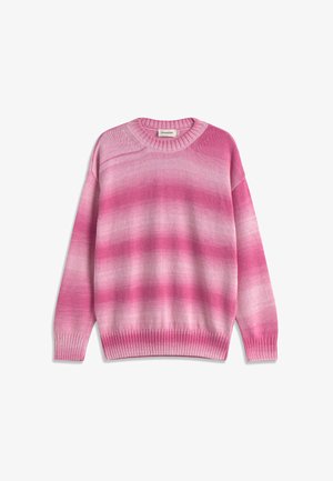 Giovane uomo che indossa un maglione a maglia sfumato rosa e bianco con polsini e orlo a coste, abbinato a pantaloni marrone scuro testurizzati.