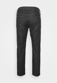 Vista traseira de jeans de ganga pretos com dois bolsos traseiros, passadores de cinto e uma pequena etiqueta com o logótipo no bolso direito e na cintura.