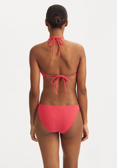Ensemble bikini à halter en corail vif. Tissu doux, lien noué à l'arrière. Le bas est taille basse avec des bords sans couture.