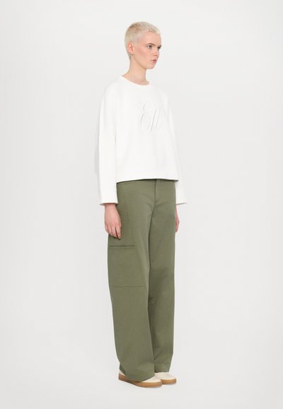 White, cropped sweatshirt with textured "E&" logo, paired with high-waisted, loose olive green pants featuring side pockets and a smooth finish.