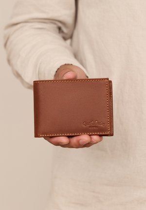 Brun læderpung med en glat overflade, bi-fold design, synlig syning og præget logo på overfladen. Kompakt størrelse til at holde i hånden.