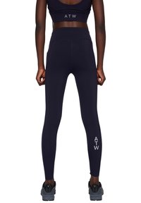 Marineblauwe leggings van rekbaar materiaal, hoge taille, met zijzakken en een logo op het linker onderbeen.