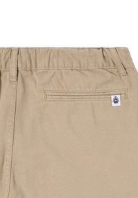 Pantaloni corti in cotone beige con cintura elastica, tasca posteriore con un piccolo etichetta a toppa e una finitura liscia e testurizzata.