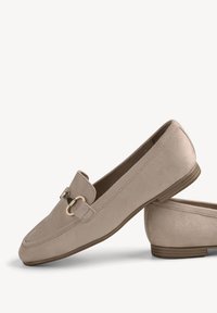 Mocassins en daim beige avec un petit talon en bois et un détail mors en métal doré à l’avant.
