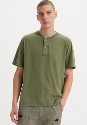 Oliivroheline lühikeste varrukatega henley särk viie nupukesega. Pehme puuvillane kangas, lõdva istuvuse ja ümmarguse kaelusega.