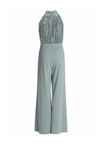 Haut sans manches en sequins argentés à col halter, associé à un pantalon gris clair à taille haute et jambes larges.