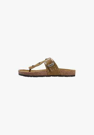 Bruine suède teenslipper met een gespstrap, studs en een kurken voetbed. Zwarte rubberen zool met een gestructureerd patroon voor grip.