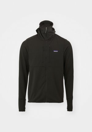 Svart zip-up jakke med høy krage, myk tekstur, lange ermer og justerbare snorer. Har en liten logo på brystet.