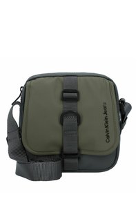 Borsa a tracolla verde in nylon con accenti grigi, una fascia con fibbia frontale, tracolla regolabile in tessuto intrecciato e dettaglio del logo sul lato.