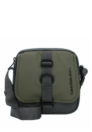 Borsa a tracolla verde in nylon con accenti grigi, una fascia con fibbia frontale, tracolla regolabile in tessuto intrecciato e dettaglio del logo sul lato.