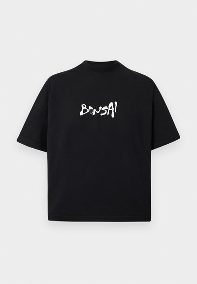 Melnas kokvilnas T-krekls ar īsām piedurknēm, ar baltu grafisku uzrakstu "BONSAI" rotaļīgā, neregulārā fontā uz krūtīm.