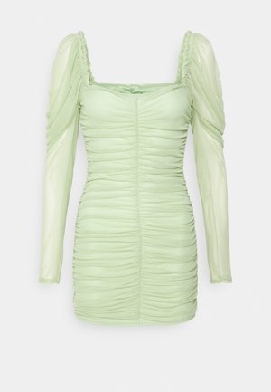 Robe bodycon vert clair froncée avec manches longues bouffantes et encolure carrée sur fond blanc.