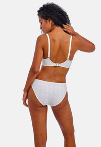 Ensemble de soutien-gorge en dentelle blanche et culotte taille haute, mettant en avant des motifs en losange complexes, des bretelles réglables et un fermoir à crochets.