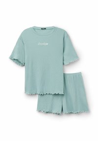 Conjunto de pijama de color azul claro con textura acanalada, que incluye una parte superior de manga corta con un borde en forma de onda y pantalones cortos a juego, ambos con bordes rizados y texto bordado.