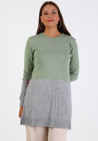 Hellgrüner und grauer gestrickter Pullover mit langen Ärmeln, einem V-Ausschnitt und strukturierten Rippdetails im unteren grauen Bereich.