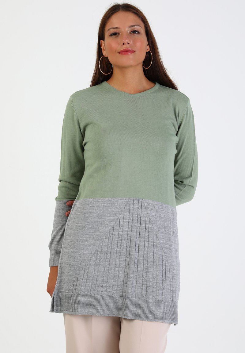 Hellgrüner und grauer gestrickter Pullover mit langen Ärmeln, einem V-Ausschnitt und strukturierten Rippdetails im unteren grauen Bereich.