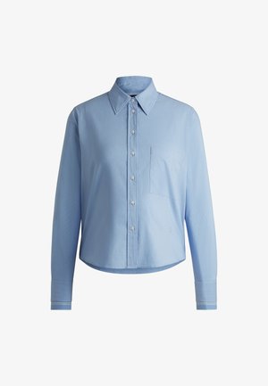 Camicia button-up azzurro chiaro realizzata in tessuto testurizzato, con colletto, maniche lunghe e taschino sul petto. Accentuata da polsini a righe.