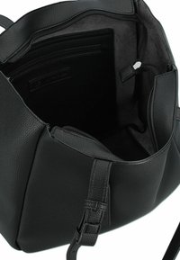 Sac à main en cuir noir avec un extérieur texturé, fermeture éclair et plusieurs compartiments intérieurs. Bandoulière ajustable et coutures détaillées.