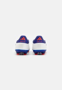 Vita fotbollsskor med blå hälar och röda dobbar på sålen. På hälen finns en framträdande Adidas-logotyp och "Copa Pure"-märkning.
