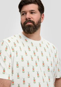 Witte katoenen t-shirt met een herhaald patroon van groene flessen met rode accenten, die een ontspannen pasvorm en casual ontwerp benadrukt.