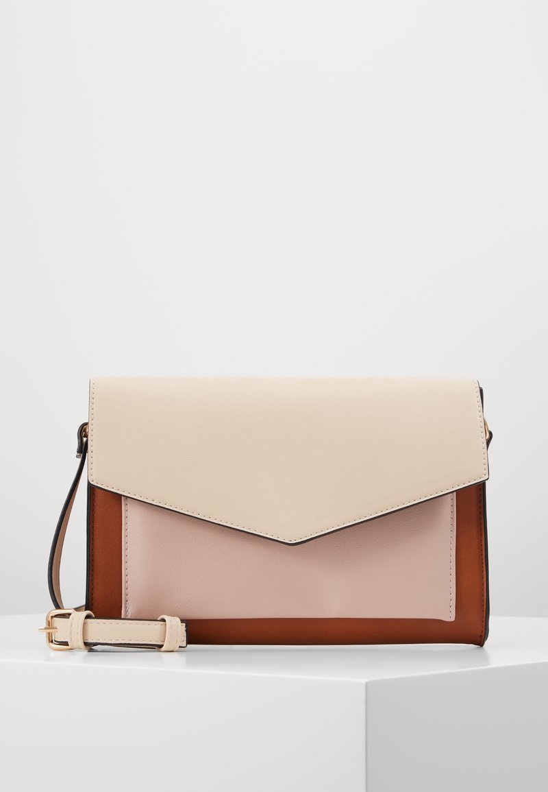 Väri-eroteltu nahkalaukku, jossa on läppä suljettu, vaaleanruskea yläosa, vaaleanpunainen keskiosa ja tummanruskea pohja. Mukana säädettävä olkahihna.