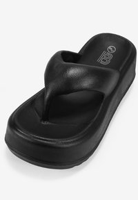 Chancla negra con material sintético texturizado, suela gruesa y diseño de tira en forma de V para el soporte del pie.