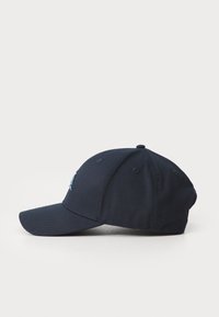 Sötétkék baseball sapka, amely anyagból készült, ívelt karimával, varrott részletekkel és szellőzőlyukakkal a légáteresztés érdekében.