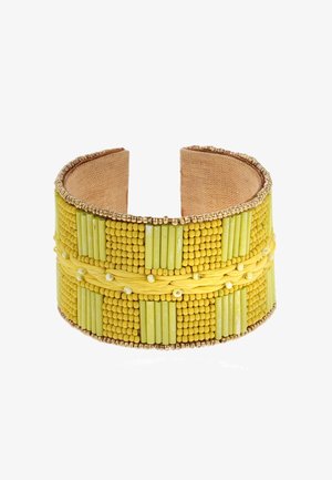 Bracelet manchette jaune en perles avec des motifs texturés, comprenant des perles rondes et cylindriques, agrémenté de détails fins en métal doré et d'une doublure beige.