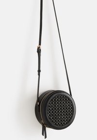 Borsa a tracolla rotonda in pelle nera con pannello frontale testurizzato, zip dorata e tracolla sottile regolabile.