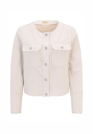Beige suedemantel met drukknoopjes, twee borstzakken en een ronde halslijn. Heeft een lichte glans en een gladde textuur.