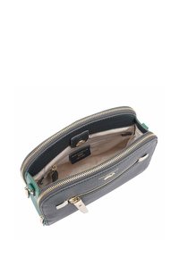 Portefeuille en cuir gris foncé avec une touche de vert. Comprend des compartiments zippés doublés et un intérieur beige avec une étiquette de logo. Détails en métal doré.