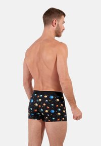 Pánské boxerky s černým podkladem, na kterém jsou barevné grafiky planet. Pás je jednobarevný černý a látka vypadá hladce a elasticky.