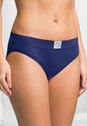 Slip di cotone blu navy con un ampio elastico in vita, caratterizzato da una piccola etichetta con un design floreale nella parte anteriore. Texture liscia e forma aderente.