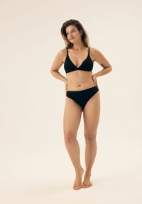 Czarny zestaw bikini z trójkątnym stanikiem i niskim dołem, wykonany z gładkiego materiału, charakteryzujący się minimalistycznym wzornictwem i cienkimi ramiączkami.