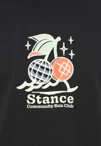 Black t-shirt featuring a graphic of two cherries, one red and one patterned, with leaves and stars, labeled "Stance Community Run Club."