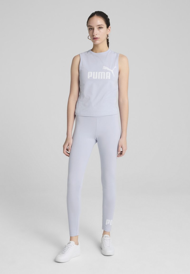 Svijetlosivi sportski komplet koji se sastoji od topa bez rukava s "PUMA" logotipom i odgovarajućim tajicama. Materijal je gladak, prilagođen tijelu, s minimalnim dizajnerskim detaljima.