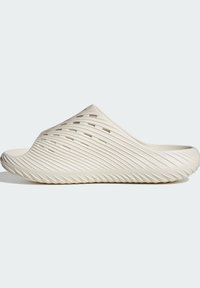 Μπεζ σανδάλι τύπου slip-on με ραβδώσεις και οπές αερισμού στο πάνω μέρος και στην σόλα, σχεδιασμένο για καθημερινή χρήση.