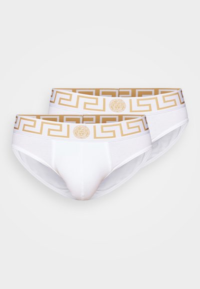 Caleçons blancs avec une ceinture à motif grec en or et blanc et un détail de logo. Tissu doux avec un ajustement confortable et une texture lisse.