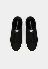 Schwarze Low-Top-Sneaker mit weißen Sohlen und schwarzen Schnürsenkeln, "JACK & JONES" Branding auf den Innensohlen, Zungen und Außenseiten, von oben gezeigt.