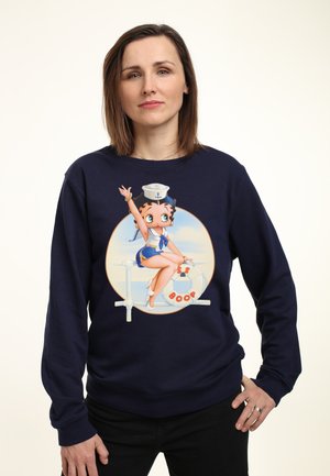 Marine sweatshirt med en tegneserieillustration af en sømand med en redningskrans. Konstruktion i bomuldsstof med lange ærmer og rund halsudskæring.