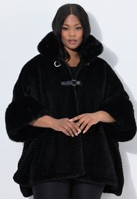 Poncho in finta pelliccia nera con texture a coste, collare oversize e dettagli in fibbia di pelle. Presenta maniche ampie e un design fluido.