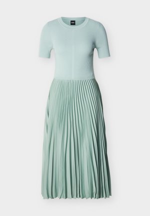 Világos menta zöld ruha bordázott rövid ujjú felsőrésszel és hosszú redős szoknyával, kerek nyakkivágással és testhezálló derékrésszel.