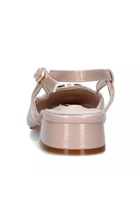 Sandal in vernice nuda con tacco basso leggermente curvo, cinturino alla caviglia e un interno liscio con soletta imbottita. Dettaglio con fibbia color oro.