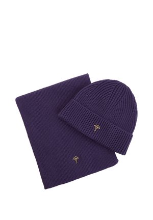 Sciarpa e berretto a coste viola con piccolo emblema floreale dorato su ciascuno, esposti su sfondo bianco.