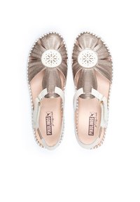 Sandales en bronze avec un design floral sur le bout, une sangle blanche ajustable et un tissu texturé. Semelle intérieure douce avec le logo visible à l'intérieur.