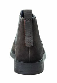 Schwarze Wildleder-Ankle Boots mit Gummisohle, ausgestattet mit einer strukturierten Fersenschlaufe und minimalistischem Design. Glatte Oberfläche ohne sichtbare Verzierungen.
