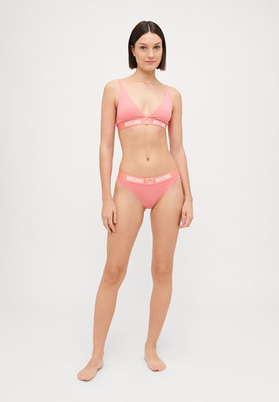 Pink bikini set featuring a triangular top with adjustable straps and matching bottoms, both displaying a white brand logo band.