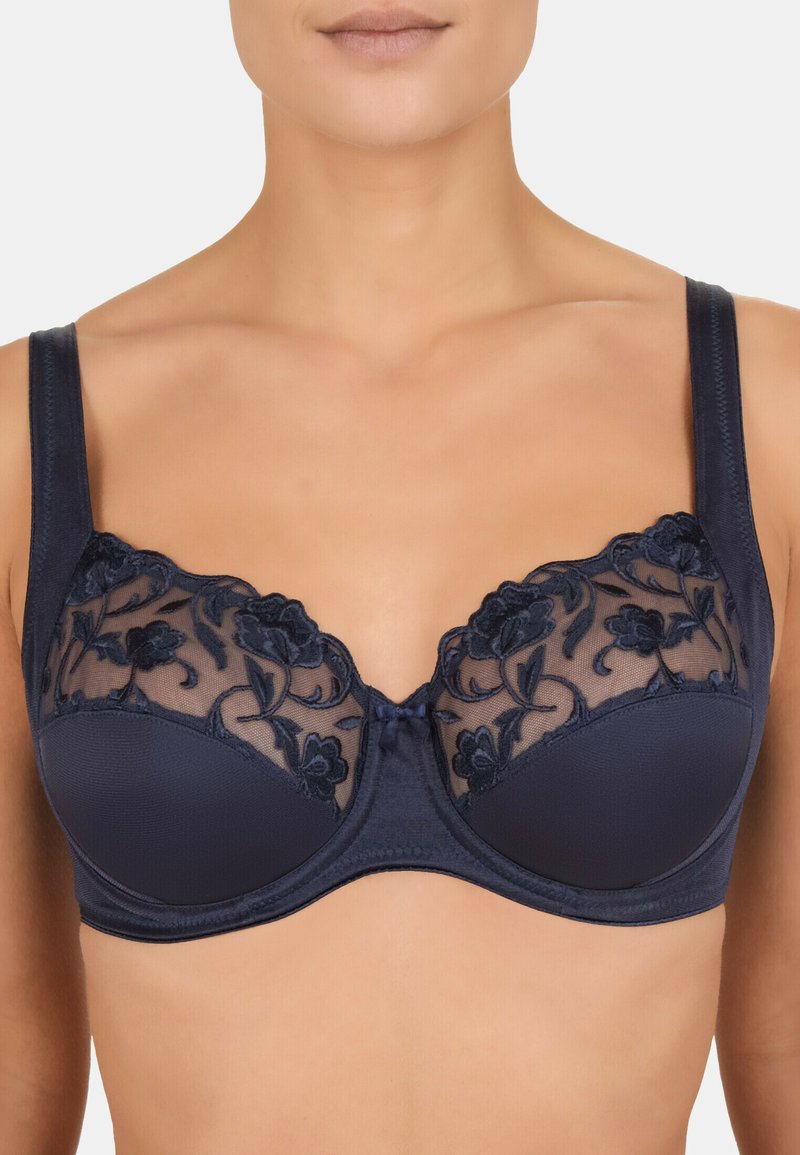Granatowy biustonosz z fiszbinami, ozdobiony przezroczystą haftowaną florą i koronkowym wykończeniem na górze. Regulowane ramiączka oraz gładki materiał miseczek.