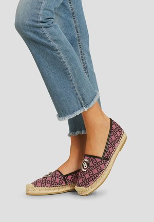 Espadrillas rosa a fantasia con profilo nero e un accento a spirale sulla punta. Suola in juta naturale. Indossate con jeans blu cropped con orli sfrangiati.