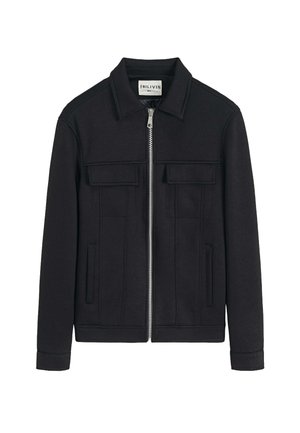 Veste noire en mélange de coton, dotée d'une fermeture éclair à l'avant, de deux poches poitrine et d'un col, avec une texture lisse et un design structuré.